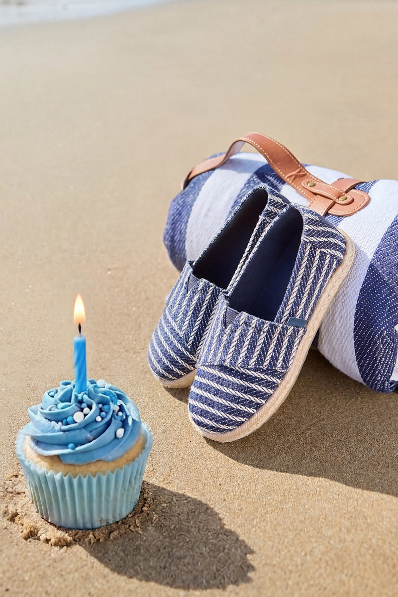 Alpargata Rope 2.0 in Navy Blue Nautical Stripe for kids on a beach with cup cake