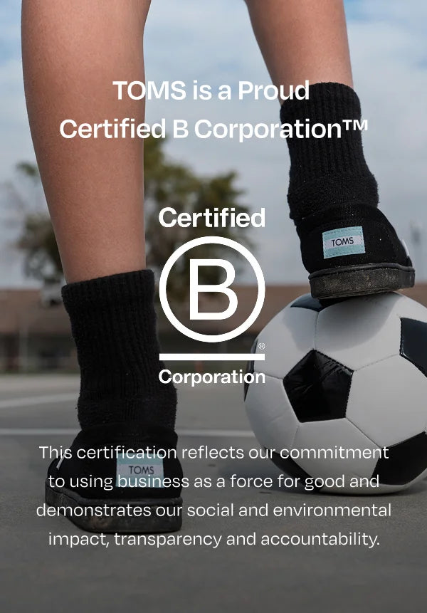B Corp logo. TOMS is er trots op een Gecertificeerd B Corporation™ te zijn Deze certificering onderstreept onze toewijding om business in te zetten als een kracht voor het goede en toont onze sociale en duurzame impact, transparantie en verantwoordelijkheid. Kind met voet op voetbal.
